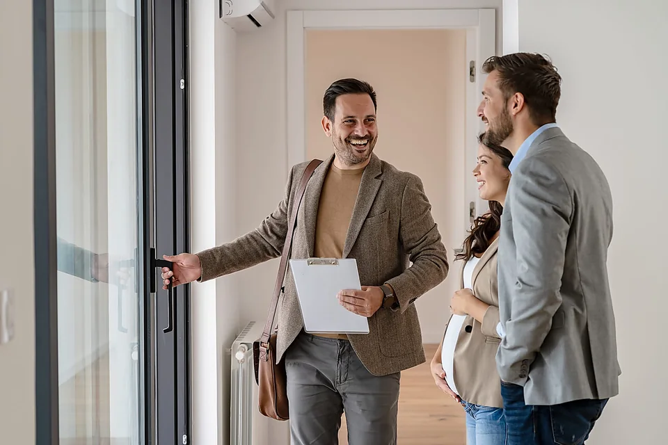 Consulente immobiliare che mostra una casa a una coppia di acquirenti