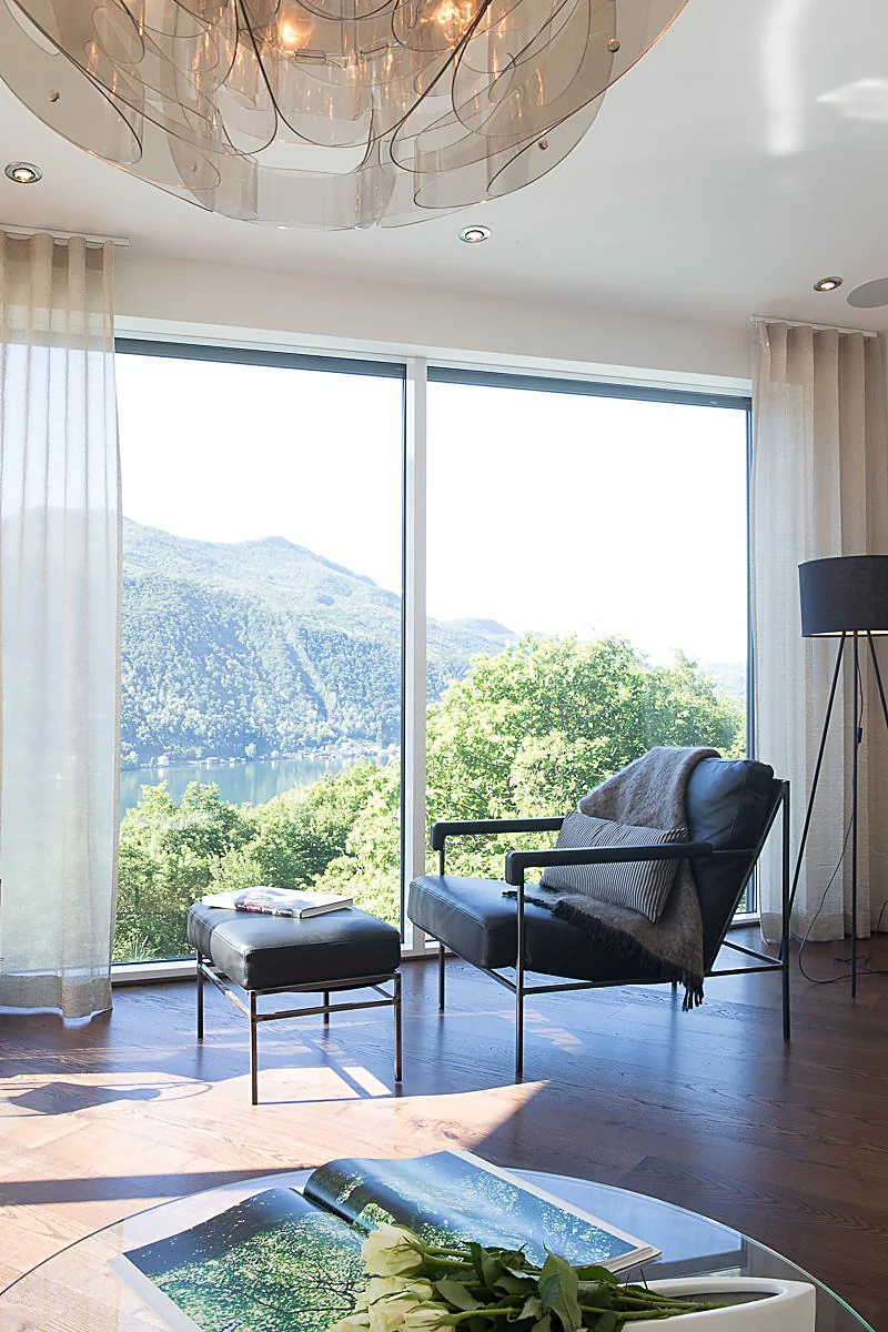 Salotto allestito con home staging e vista panoramica sul lago